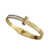 Bracelet jonc doré pour femme avec design inspiré du clou, orné de détails brillants sur la partie supérieure et doté d'une fermeture intégrée discrète.