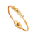 Bracelet jonc doré pour femme avec motif nœud central et détails brillants décoratifs, design élégant et féminin.