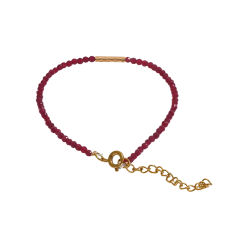 Bracelet Ruby Line pour femme avec perles rouges facettées, détails dorés en acier inoxydable et chaînette d'extension ajustable.