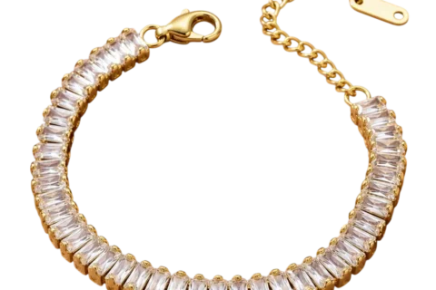 Bracelet femme doré avec rangée de cristaux rectangulaires transparents montés sur une structure dorée et fermeture ajustable.