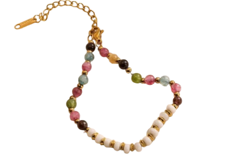 Bracelet femme haut de gamme en pierres naturelles pastel multicolores avec perles blanches et finitions dorées, présenté sur un tissu satiné beige.