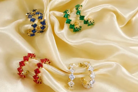 Boucles d’oreilles créoles pour femme avec pierres carrées colorées bleu, vert, rouge et transparent sur monture dorée élégante.