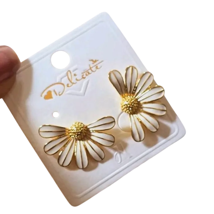 Paire de boucles d'oreilles pour femme en forme de marguerite, finition dorée, pétales blancs et fermeture à tige, au style élégant et tendance.