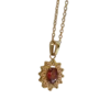 Collier doré pour femme avec pendentif composé d'une pierre rouge ovale entourée d'un halo de petites pierres scintillantes, au style élégant et raffiné.