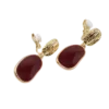 Boucles d'oreilles à clip pour femme en métal finition dorée avec élément décoratif texturé et pendentif bordeaux de forme organique.