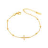 Bracelet chaîne doré pour femme avec pendentif croix serti de petits détails scintillants et perles décoratives sur la chaîne.