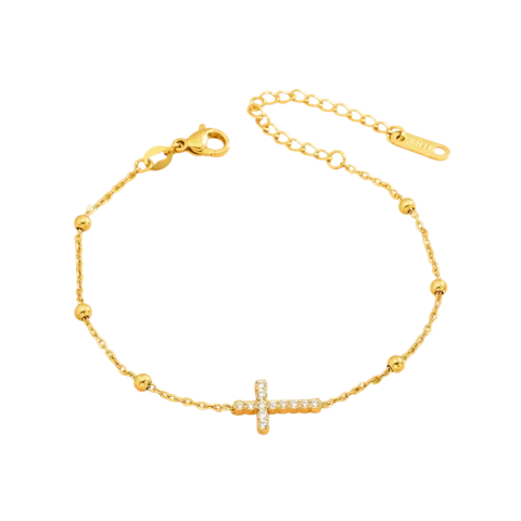Bracelet chaîne doré pour femme avec pendentif croix serti de petits détails scintillants et perles décoratives sur la chaîne.