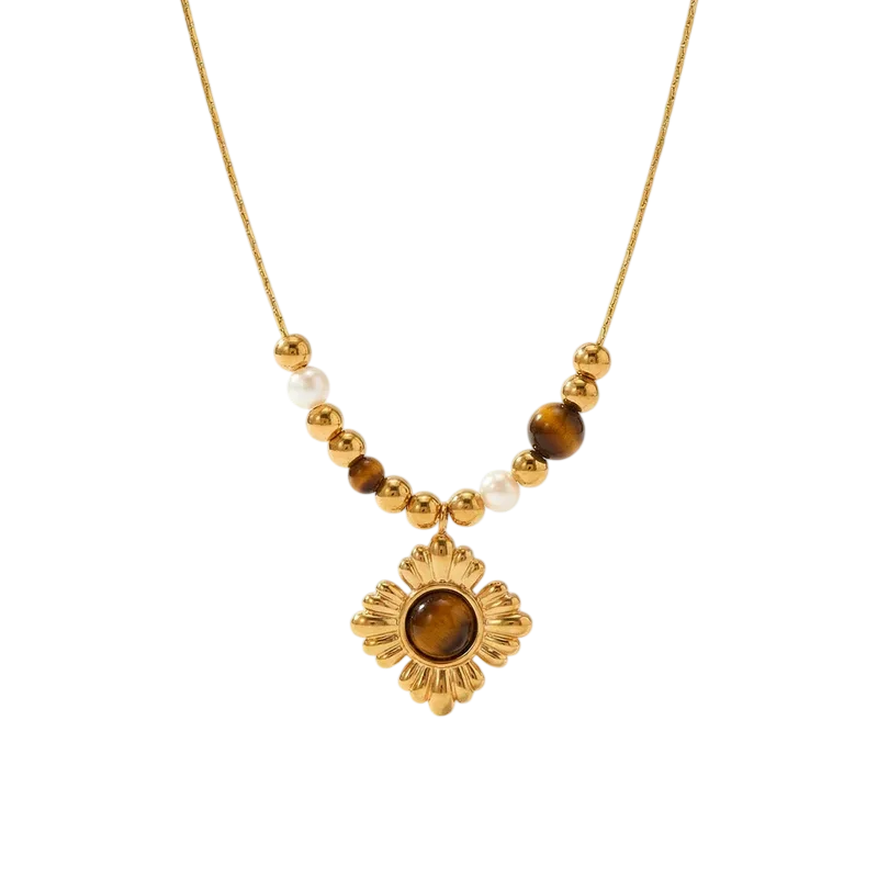 Collier doré pour femme avec pendentif fleur à cabochon brun et perles décoratives blanches et brunes sur la chaîne.