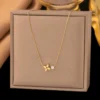 Collier femme doré avec chaîne fine, pendentif trèfle à quatre feuilles et perle blanche au design élégant et minimaliste.
