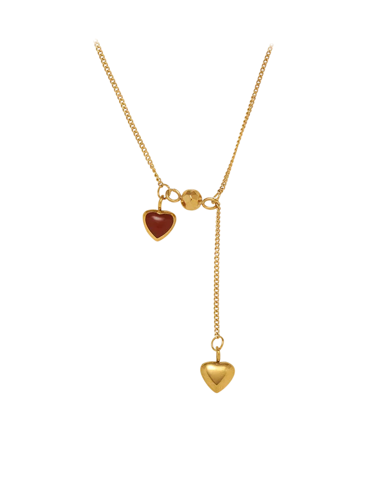 Collier en acier inoxydable doré avec deux pendentifs en forme de cœur, dont un cœur rouge et une chaîne pendante élégante.